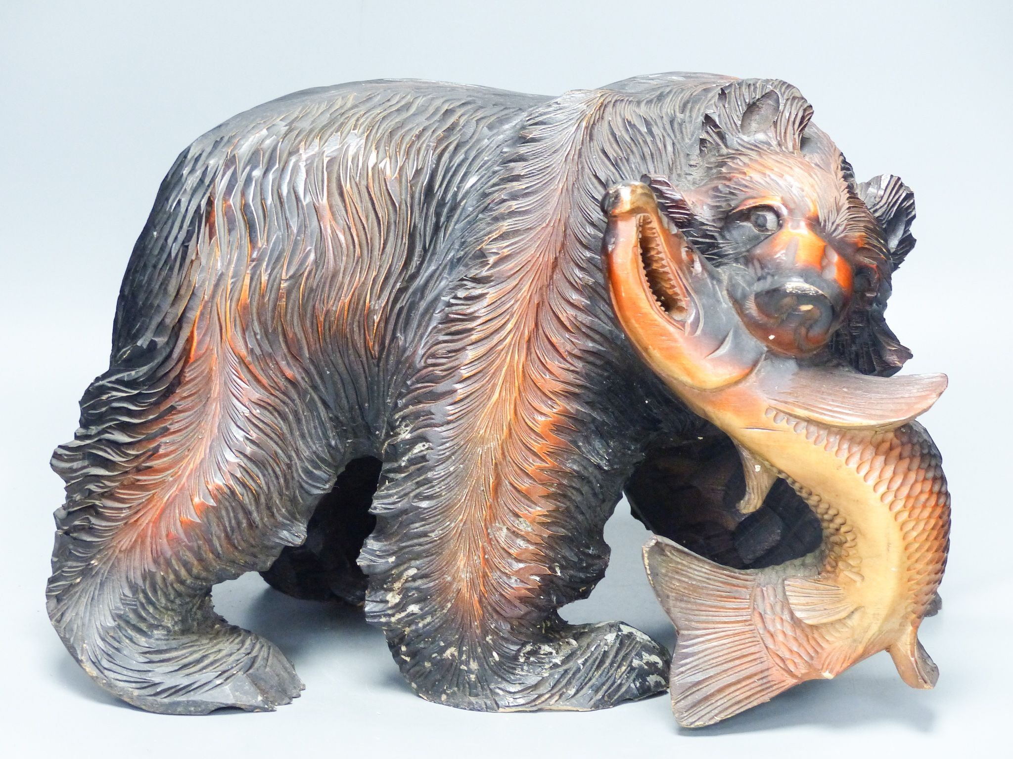 A large carved wood group of a bear and a fish 40cm